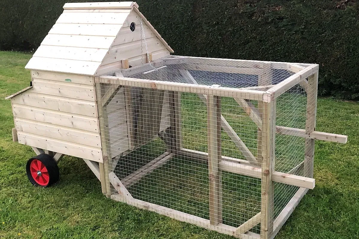 Ranger on Wheels — the standard mobile coop with wheels and lifting handles, garden setting.