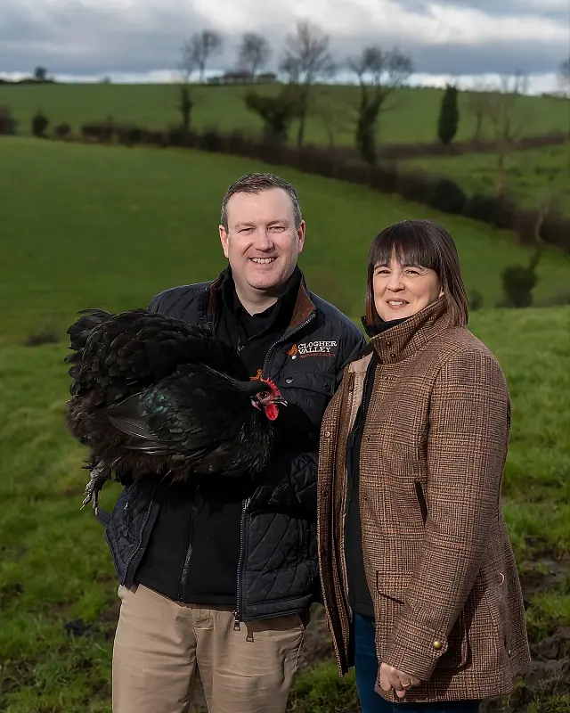 The Clogher Valley family at the Clabby Road farmstead, holding a champion black rooster